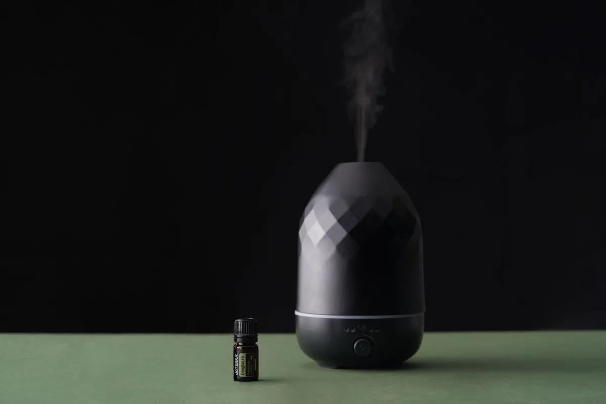 Difusor de aromas junto a un frasco de aceite esencial